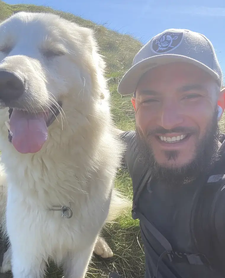 Nicolas Moussa, fondateur de CaliaLabs, souriant en randonnée avec son chien blanc.